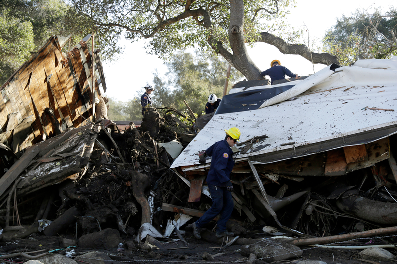 Search and rescue personnel scan a home in the aftermath of a mudslide Saturday, Jan. 13, 2018, in Montecito.